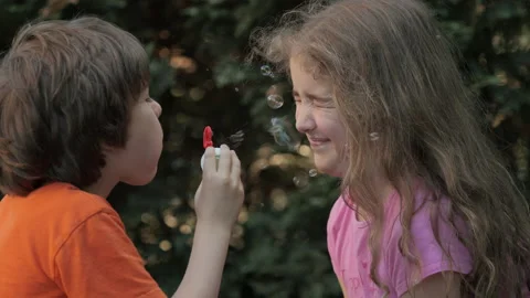 Children Blowing Soap Bubbles Having Fun Playing Outside, Innocence and Cur.. Video stock 303938929