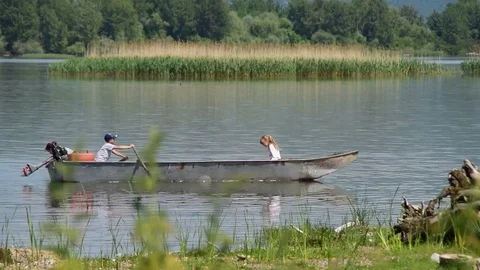 Children in the boat on the lake,boy is rowing and girls are watching around Stock Footage