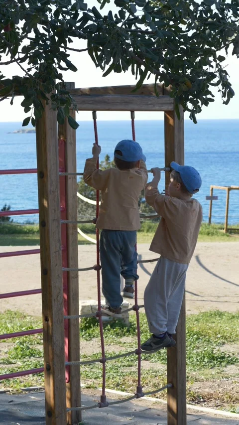 Children boys climbing playground structures, demonstrating coordination Video stock 332896321