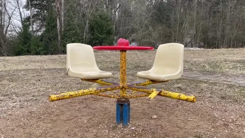 Children broken carousel abandoned playground first snow forest red swings Stock Footage 310371628