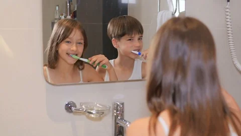 Children brush their teeth. A boy and a girl brush their teeth in the bathroom.  Stock Footage 77559359