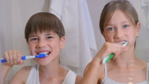 Children brush their teeth. A boy and a girl brush their teeth in the bathroom.  Stock Footage 80331062