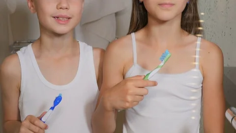 Children brush their teeth. A boy and a girl brush their teeth in the bathroom.  Stock Footage 80332255