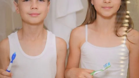 Children brush their teeth. A boy and a girl brush their teeth in the bathroom.  Stock Footage 80333096