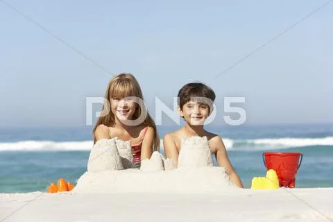 Children Building Sandcastles On Beach Holiday Stock Photos