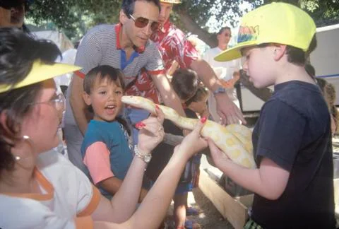 Children with a Burmese albino python snake Photos