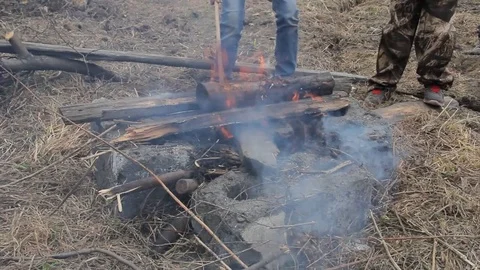 Children burn a bonfire on the background of an old destroyed wooden house Stock Footage 74948081