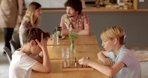 Children in cafe playing chess stands as timeless example of tabletop game kids. Stock Footage 248865409