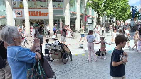 Children Chasing Giant Soap Bubbles in a Pedestrian Zone Stock Footage 341175665