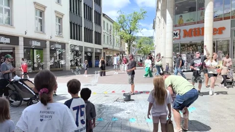 Children Chasing Giant Soap Bubbles in Front of Müller Drugstore Stock Footage 341439614