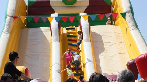 Children climb and slide on inflatable rubber castle playground Stock Footage 24014881
