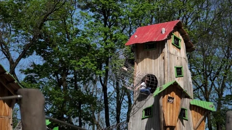 Children climb a high attraction while playing on the playground Stock Footage 273598395