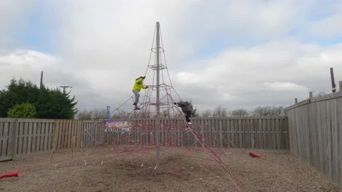 Children climbing and having fun at a playground designed for kids. Stockbeeldmateriaal 238560208