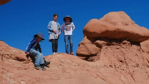 Children climbing down off a redrock formation Stock Footage 106603893