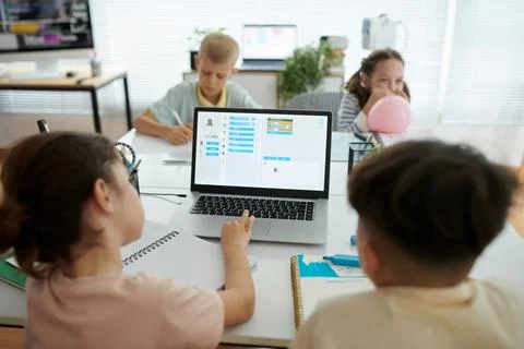 Children Collaborating on Computer Coding Project in Classroom Stock Photos