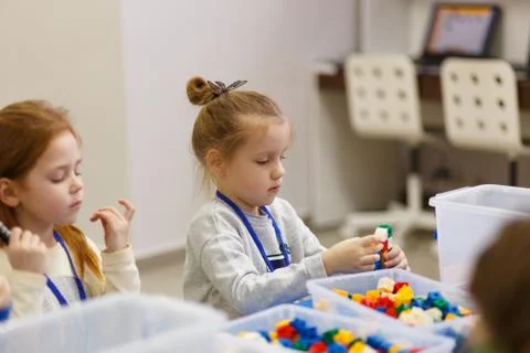 Children collect various objects from plastic parts of the constructor Stock Photos