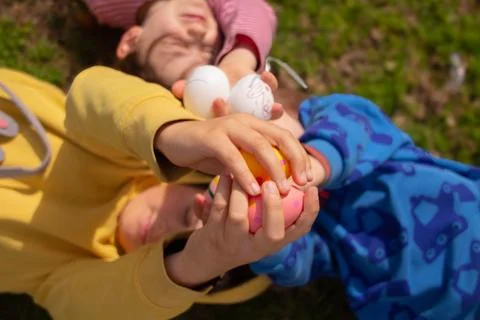 Children collecting easter eggs during outdoor spring hunt Stock Photos