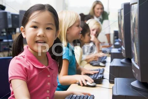 Children at computer terminals with teacher in background (depth of field/high Stock Photos