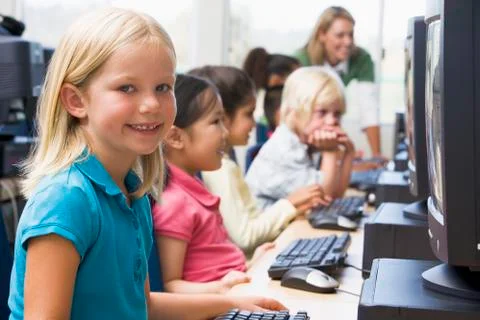 Children at computer terminals with teacher in background (depth of field/high Stock Photos