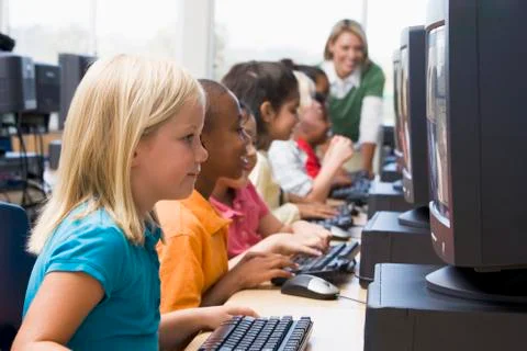 Children at computer terminals with teacher in background (depth of field/high Stock Photos
