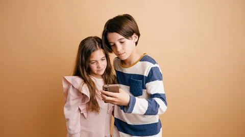 Children connecting with technology using a smartphone Stock Photos