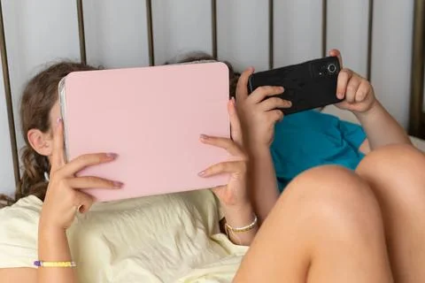 Children consuming digital content on tablet and phone 스톡 사진