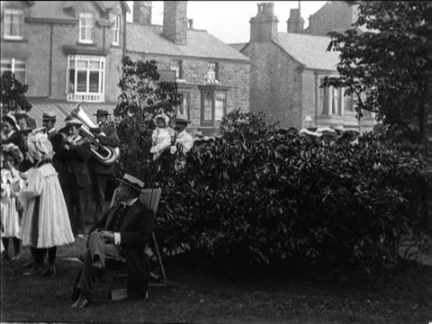 Children dancing around a maypole at Well Dressing celebration, Buxton UK 1904 Video stock 136672943