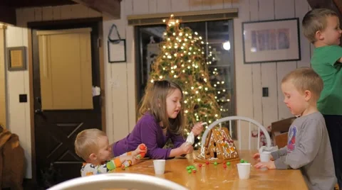 Children Decorating gingerbread house Stock Footage 58637434