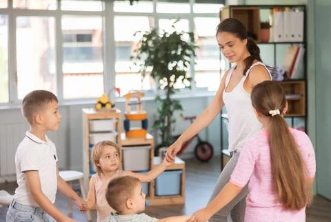 Children of different ages dancing with young teacher Stock Photos
