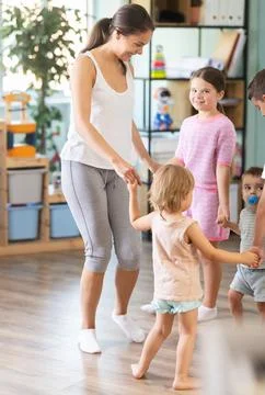 Children of different ages dancing with young teacher Stock Photos