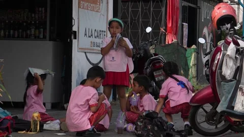 Children doing homework on the sidewalk. Education in Thailand. Stock Footage 315878701