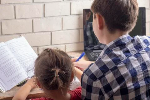 Children doing homework, sitting at table and reading Stock Photos