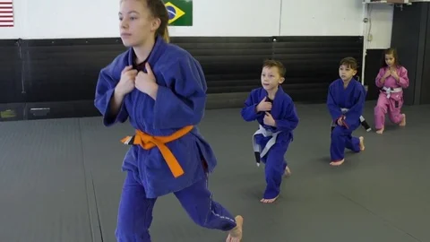 Children doing lunges in a dojo 動画素材 77093295