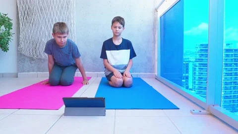 Children doing sport exercises, doing stretching exercise on yoga mat while Stock Footage 133456906