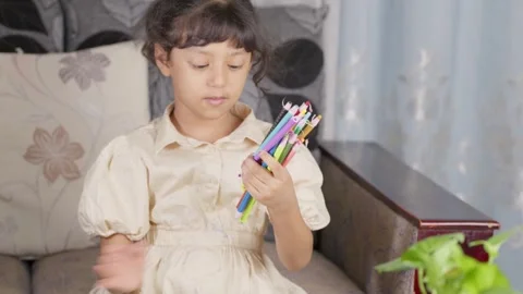 Children Drawing in a Coloring Book with Colored Pencils Stock Footage 281358859