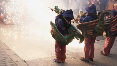 Children Dressed as Correfoc Dragons spraying fireworks Stock Footage 100389213