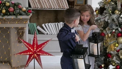 Children dressed in elegant clothes adorn a tree of roses. hold lanterns Stockbeeldmateriaal 85134457