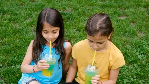 Children drinking cocktail on grass. Selective focus. Stock Footage 304672960