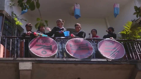 Children dropping and spraying water from the balcony on the people walking down Stock Footage 77448951