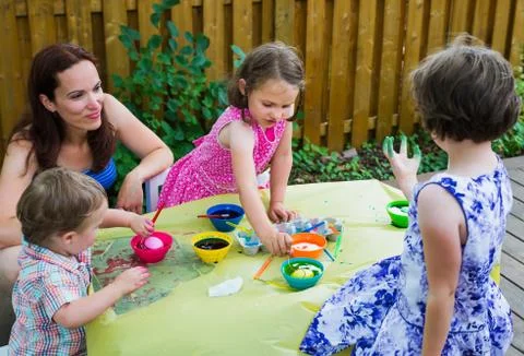 Children Dyeing Easter Eggs Outside Stock Photos