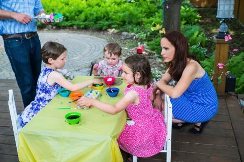 Children Dyeing their Easter Eggs Outside Stock Photos