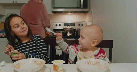 Children eat breakfast at the kitchen table. Stock Footage 229154390