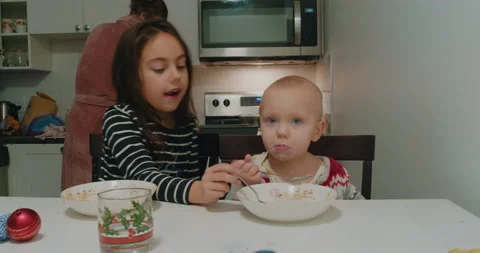Children eat breakfast at the kitchen table in the kitchen. Stock Footage 229154662