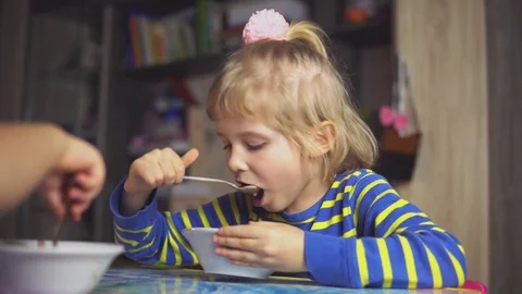 Children eat from the plates at the table Stock Footage 81889056