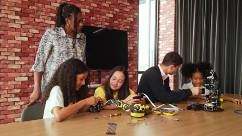 Children engage in hands-on STEM learning with robotics kits and teacher. Stock Footage 312192910