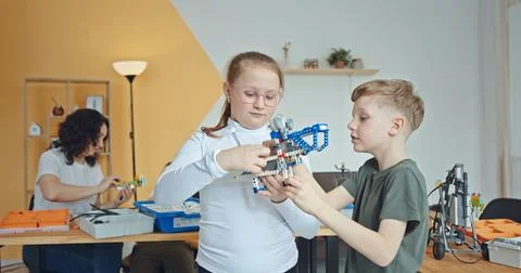 Children Engaged in Collaborating on an Exciting Robotics Project within a Stock Photos