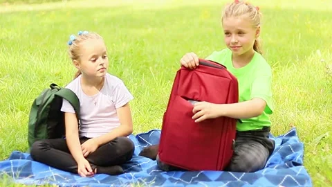 Children enjoy a picnic in the park while sharing stories and snacks Vídeos de archivo 296333112