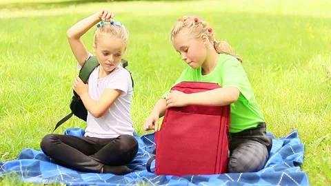 Children enjoy a picnic in the park while sharing stories and snacks 스톡 동영상 296334939