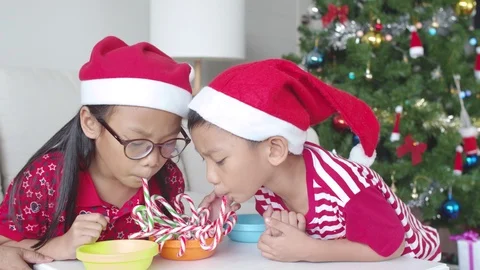 Children enjoy playing with candy cane on Christmas day Stock Footage 119856580