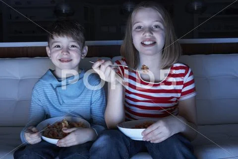 Children Enjoying Meal Whilst Watching TV Stock Photos